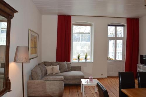ein Wohnzimmer mit einem Sofa und 2 Fenstern in der Unterkunft Ferienwohnung Bernhard in Zinnowitz