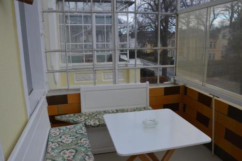 d'un balcon avec une table et des chaises blanches ainsi qu'une fenêtre. dans l'établissement Ferienwohnung Bernhard, à Zinnowitz