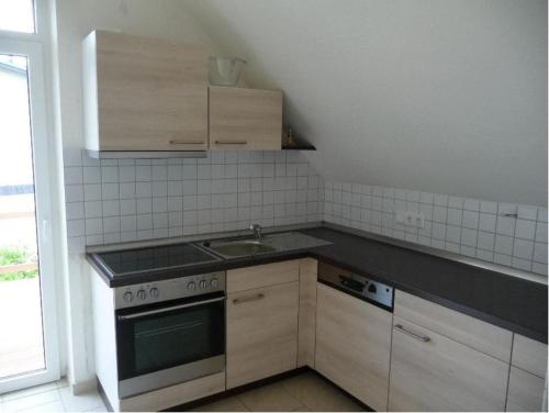 een keuken met een wastafel en een fornuis top oven bij Ferienwohnung Ida in Ahlbeck