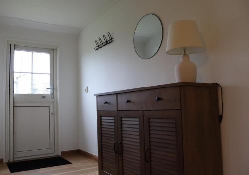 a mirror on top of a dresser in a room at Hoeve de Zeeanjelier in Sint Annaland