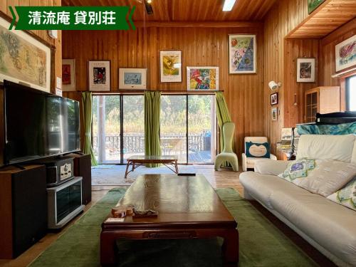 a living room with a couch and a tv at まんのう清流庵 in Manno