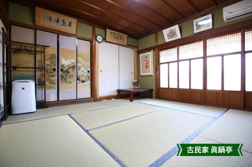 an empty room with a large room with windows at まんのう清流庵 in Manno