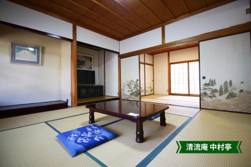 a living room with a table and a tv at まんのう清流庵 in Manno