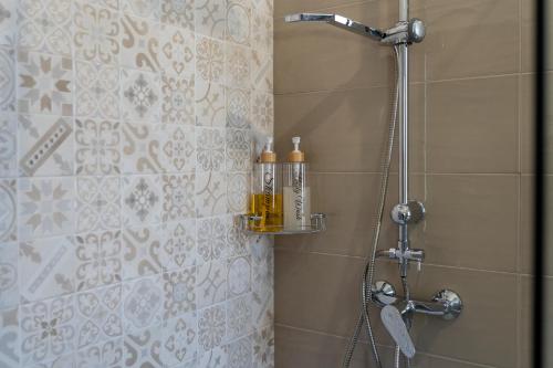 ein Badezimmer mit einer Dusche mit zwei Flaschen an der Wand in der Unterkunft Smilax - Hydruntum Holiday Rooms in Otranto