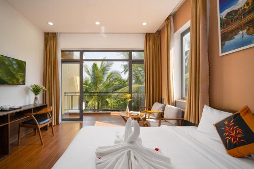 a hotel room with a bed and a desk at Flower Villa in Hoi An