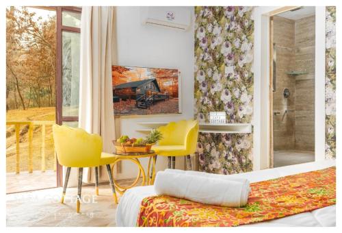 ein Schlafzimmer mit einem Bett, einem Tisch und gelben Stühlen in der Unterkunft Snow Resort Gulmarg in Gulmarg