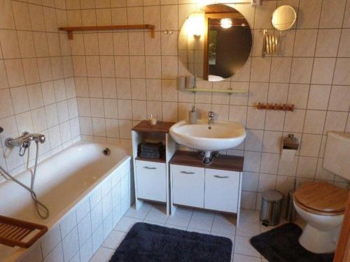 La salle de bains est pourvue d'un lavabo, d'une baignoire et de toilettes. dans l'établissement Ferienwohnung-Himmelpforte, à Wernigerode