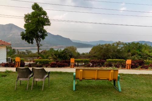 two chairs and a ping pong table in the grass at Residency Lake Resort & Spa in Mulshi