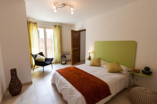 sypialnia z łóżkiem z zielonym zagłówkiem i krzesłem w obiekcie Erbalunga - Résidence Les Bosquets - Cap corse Location w mieście Brando