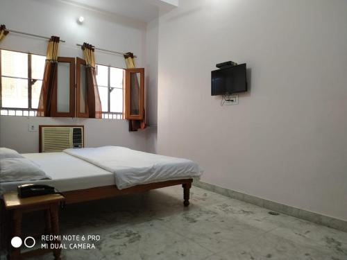 BOBY HOME STAY "BOBY MANSION" Jaipur في جايبور: غرفة نوم مع سرير وتلفزيون على الحائط