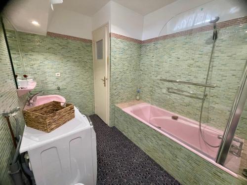 baño con bañera rosa y aseo rosa en Villa Lé Luquentia-Bassin d'Arcachon, en Gujan-Mestras