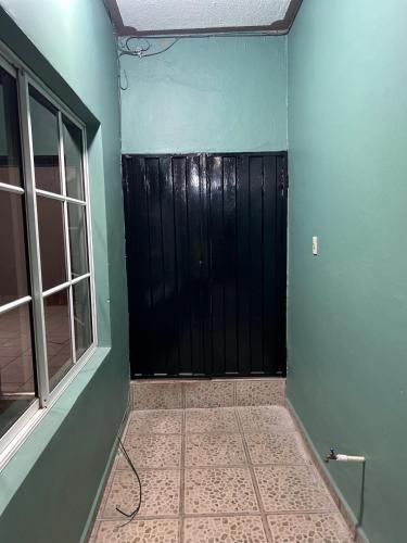 a room with a black door and a window at Casco histórico Atenea in Comayagua