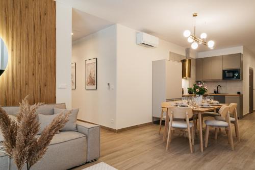 a living room and kitchen with a table and a couch at Muse - LoftAffair Spa Collection in Kraków
