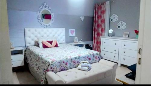 - une chambre avec un lit blanc et des oreillers roses dans l'établissement PdLuz Casa Completo e Confortável, à São Paulo