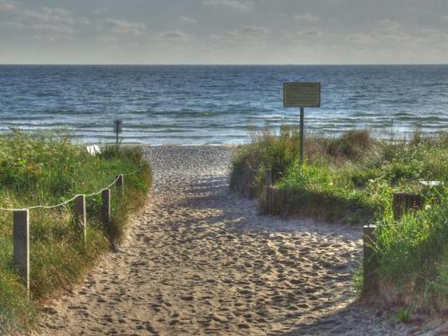 um caminho para a praia com um sinal em Villa Strandperle, App 05 - nur 20m zum Strand, TOPLAGE em Binz