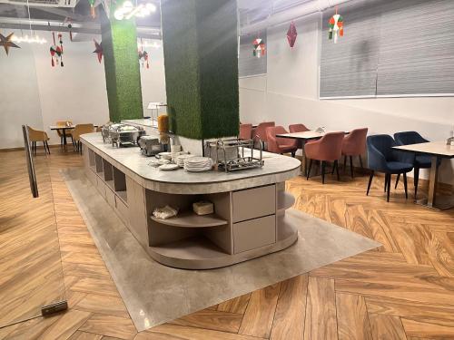 a restaurant with a counter and tables and chairs at Gazebo Inn & Suites Medanta in Gurgaon