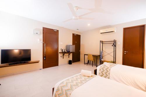 a hotel room with a bed and a flat screen tv at Rebungan Resort Langkawi in Kuah