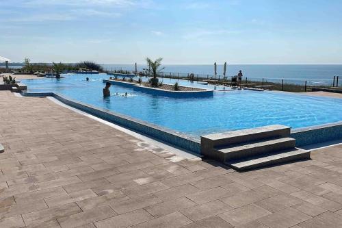 a large swimming pool with people in it next to the ocean at Our dreamy holiday home by the sea in Pomorie