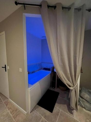 Cette chambre bleue dispose d'une baignoire avec un rideau. dans l'établissement Studio Cocoon, à Saint-Martin