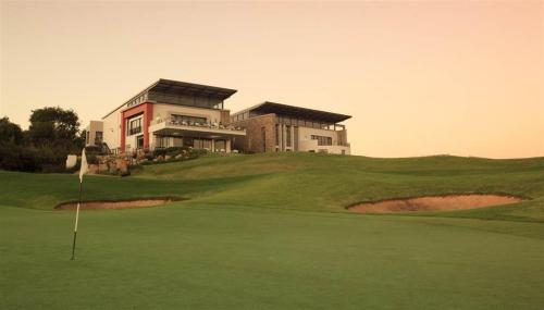 una casa en la cima de una colina con un putting green en 82 St Andrews Jackal Creek Golf Estate with Backup power & Golf course views, en Roodepoort