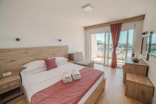 una camera da letto con un letto e due pantofole sopra di Hotel NOBEL Ulcinj a Ulcinj