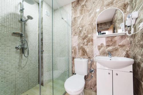 uma casa de banho com um chuveiro, um WC e um lavatório. em Hotel NOBEL Ulcinj em Ulcinj