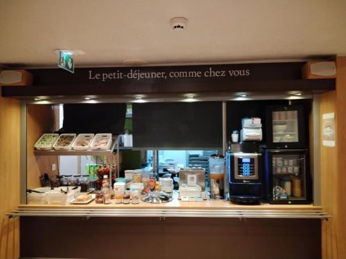 a counter in a restaurant with a coffee shop at Hotel Inn Design Montluçon in Montluçon