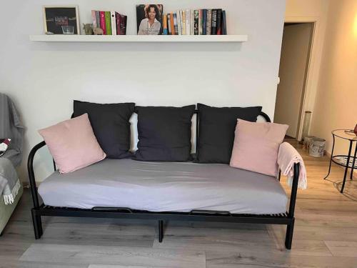 - un canapé avec des oreillers roses et noirs dans l'établissement Gemütliche Einliegerwohnung (2 Zimmer), Schönaich, à Schönaich