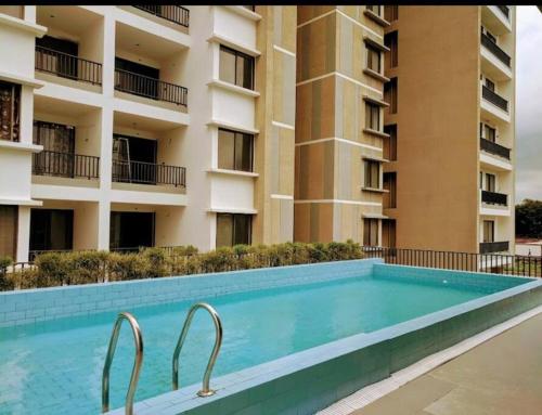 a swimming pool in front of a building at BRIJ Homes- 2 Bedroom Premium Apartment in Indore