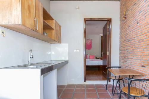 a kitchen with a table and chairs and a brick wall at Nary Garden in Kampot