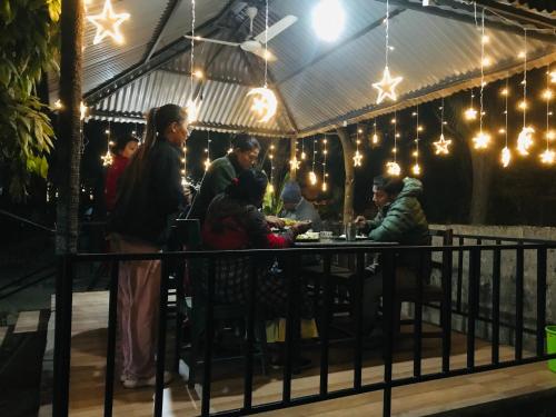 grupa ludzi siedzących przy stole w namiocie w obiekcie BABA lodge & restaurant w mieście Sauraha