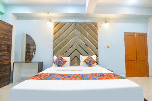 a bedroom with a large bed with a wooden headboard at FabExpress MU Club in Patna