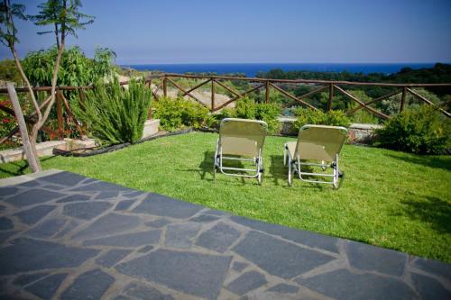 two chairs sitting on the grass in a yard at Petroto Villas in Kiotari
