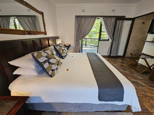 a bedroom with a large bed with white sheets and pillows at Leopard Corner Lodge in St Lucia
