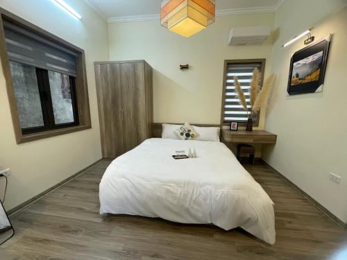 um quarto com uma grande cama branca e uma janela em Happy House 301 1bed1room 40m2,Balcony,near Ho Tay Lake em Hanói