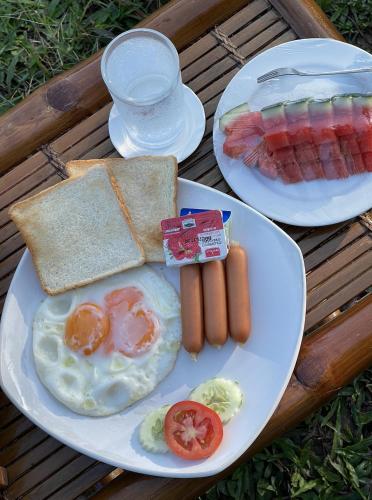 zwei Teller mit Frühstückslebensmitteln auf dem Tisch in der Unterkunft Sawasdee Lagoon Camping & Restaurant in Ban Lam Pi