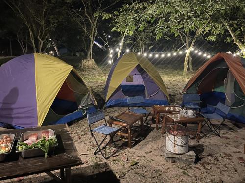 Ban Lam PiにあるSawasdee Lagoon Camping Resortのテント2室、汚れたテーブルと椅子