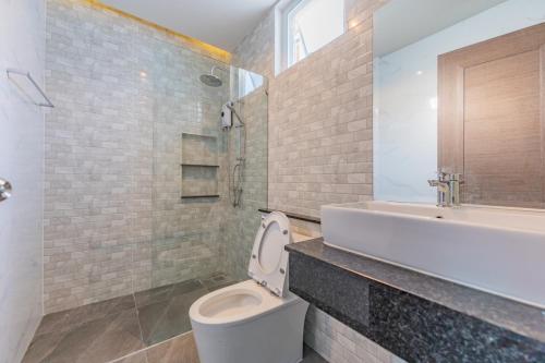 Un baño con inodoro, lavabo y bañera. en Pandara pool villa cha-am, en Cha Am