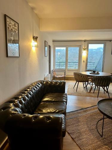 un salon avec un canapé en cuir et une table dans l'établissement Les Villas de la Plage, à Névez