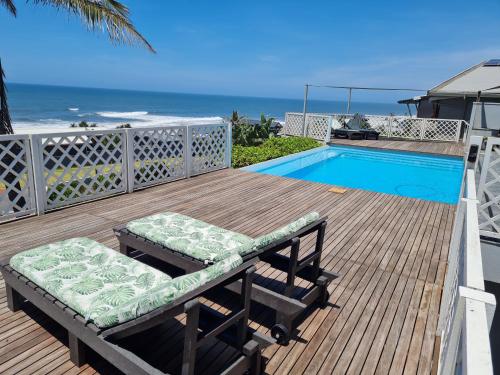a deck with two benches and a swimming pool at Fairview Guesthouse in Ballito