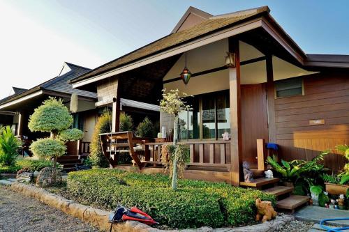 a house with a porch with a table and chairs at Huen Pak Mon Chantra in Chiang Rai