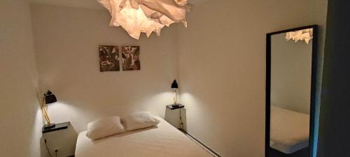 une chambre avec un lit et un grand miroir dans l'établissement Appartement 4 personnes, à Port-la-Nouvelle