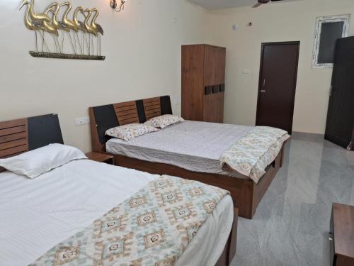 1 Schlafzimmer mit 2 Betten und einem Tisch in der Unterkunft PENTHOUSE APARTMENT in Madurai