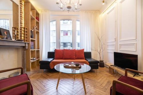 un salon avec un canapé et une table dans l'établissement Lille Hypercentre -Appartement 2ch, 5p, à Lille