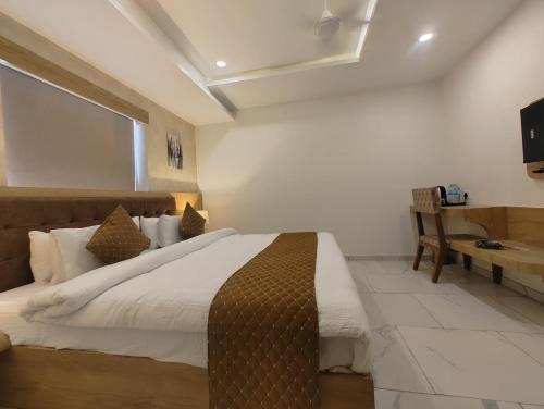 1 dormitorio con 1 cama grande y escritorio en Signum Cityscapes The Royal Castle Plaza, en Rajkot