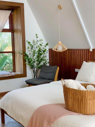 a bedroom with a bed with a chair and a window at กลิ่นไอทุ่งโฮมสเตย์ in Ban Thum