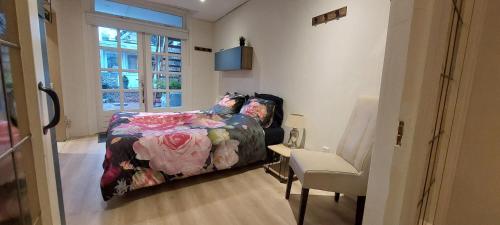 um quarto com uma cama, uma cadeira e uma janela em B&B 't Morregaât em Weert