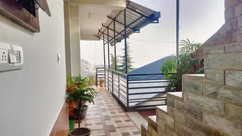 a balcony with a view of a building with plants at Paradiso Guest House in McLeod Ganj