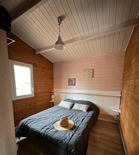 une chambre avec un lit avec un chapeau dessus dans l'établissement Camping les Lacs d'Armagnac, à Bretagne-dʼArmagnac