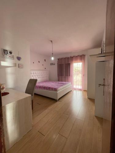 a bedroom with a bed and a table and a window at Guest House Perazić in Bar